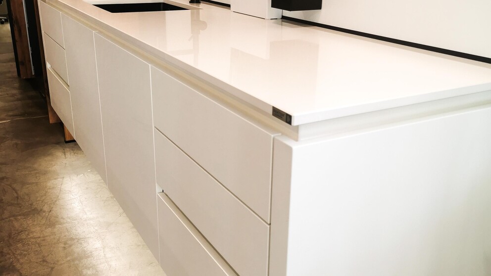 wandhängende Küchenzeile für Spüle und Arbeitfläche, Arbeitsplatte aus Dekton weiß hochglanz.